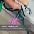 Hand Attaching C9 Quick Clip to Roof Edge or Railing. Text reads: Hang in Half the Time