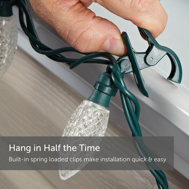 Hand Attaching C9 Quick Clip to Roof Edge or Railing. Text reads: Hang in Half the Time