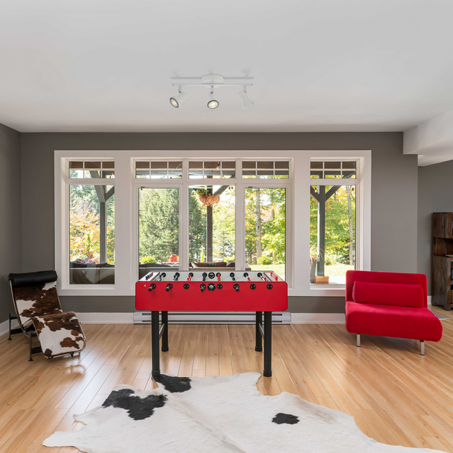 Summerhill Track Lighting Kit hanging on a white ceiling above a modern living space with red and black furniture