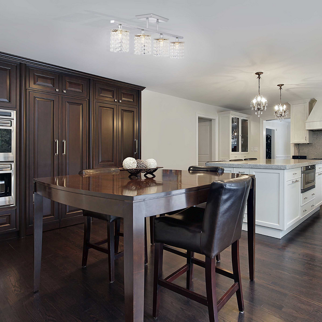 Cora track light mounted on a ceiling illuminating a table underneath - dark wood kitchen setting