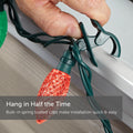 Hand Attaching C9 Quick Clip to Roof Edge or Railing. Text reads: Hang in Half the Time